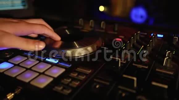 在迪斯科俱乐部的现代CDUSB播放器上播放派对音乐的DJ特写视频的预览图