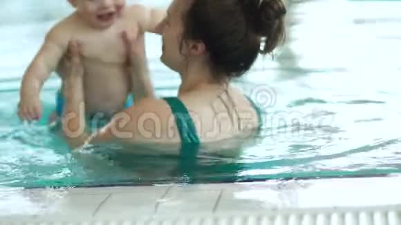 婴儿和他妈妈在室内游泳池游泳孩子对这个过程很高兴也很有激情妈妈天视频的预览图