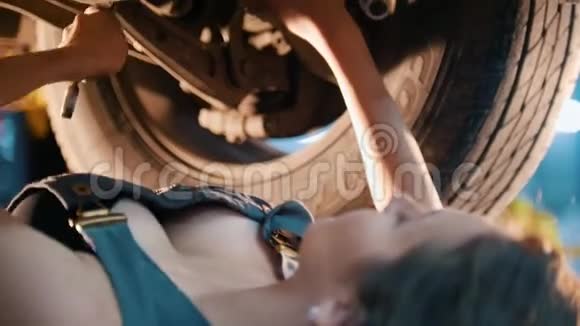 机械师女孩躺在车下用扳手修理它擦汗关门视频的预览图