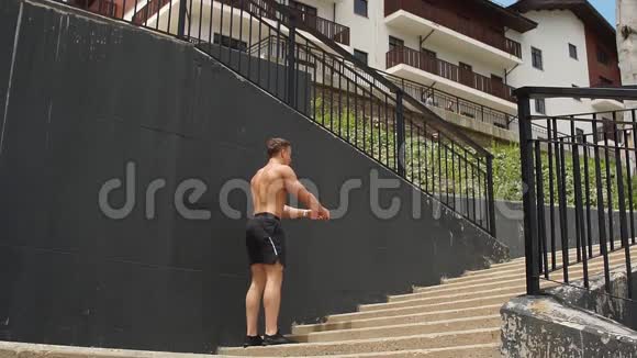 年轻运动员在楼梯上跳楼跑步前热身视频的预览图