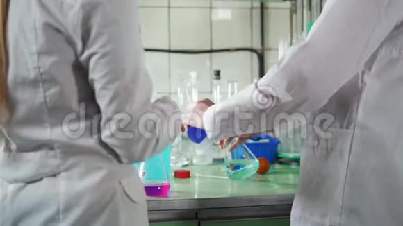 两个年轻女子在化学实验室混合化学药品视频的预览图