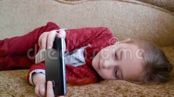 少女躺在沙发上打电话视频的预览图
