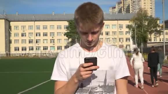 一个年轻人用智能手机穿过体育场视频的预览图