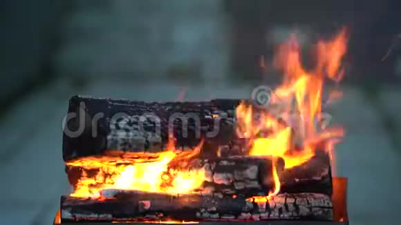 明亮的火和蓝色的烟雾笼罩着烤架里滚烫的干柴视频的预览图