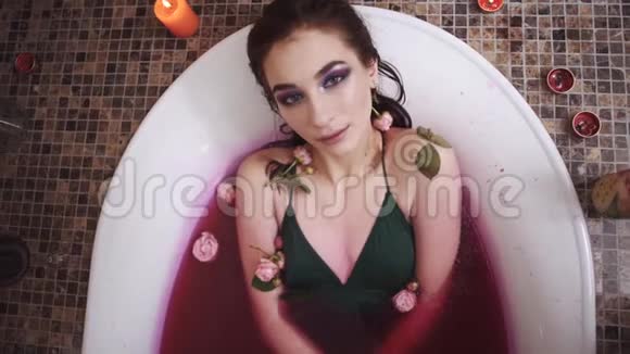 美丽性感的年轻女人在水疗沙龙里用玫瑰放松洗澡可爱的女孩在浴室里享受视频的预览图