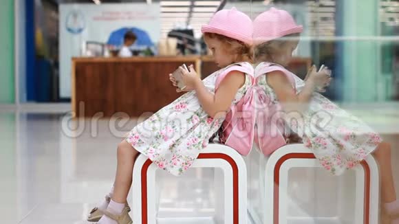 小女孩游客在机场玩手机等待他的旅行航班视频的预览图