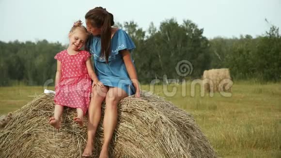 美丽的女人和五岁的孩子坐在干草堆上视频的预览图