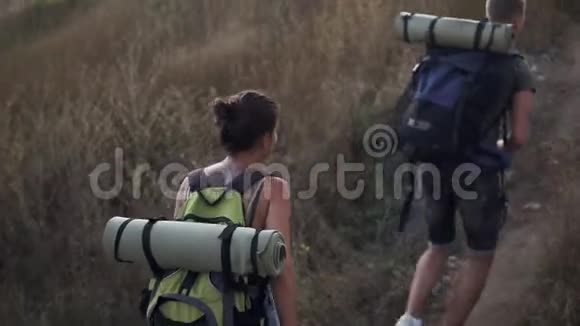 两个旅行者的高角度镜头男人和女人正在爬山背着游客的背包上午视频的预览图