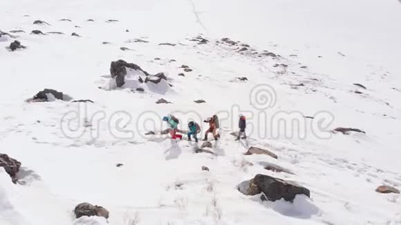四名游客在大雪中互相跟随用滑雪杆帮助自己最后一个游客盯着视频的预览图