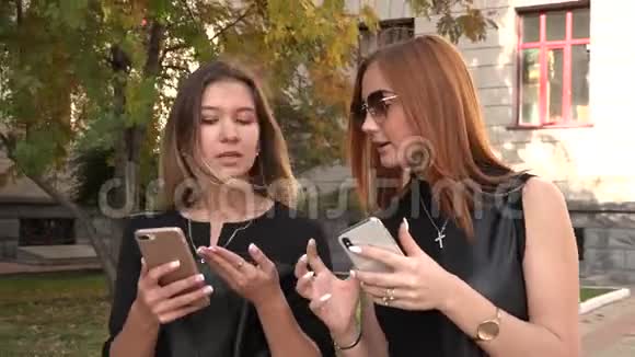 两个女朋友走在街上用智能手机聊天视频的预览图