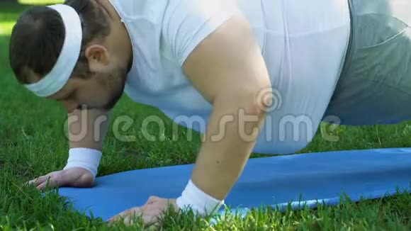 超重的人在户外做仰卧起坐锻炼渴望减肥视频的预览图