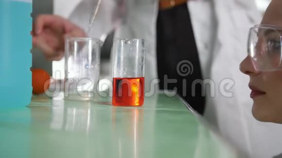 化学实验室年轻女子做实验尝试不同的化学反应混合液体视频的预览图