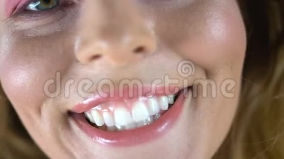 年轻女子真诚微笑露出洁白健康的牙齿提供牙科服务视频的预览图