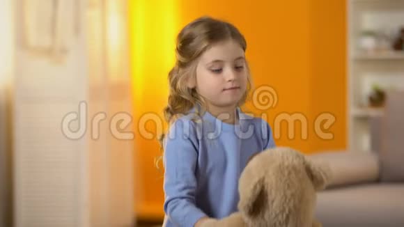 快乐的金发小女孩玩最喜欢的玩具熊童年视频的预览图