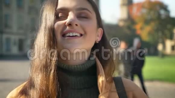 令人惊叹的快乐白种人女性正微笑着特写镜头在镜头前展示她的喜悦城市氛围阳光明媚视频的预览图