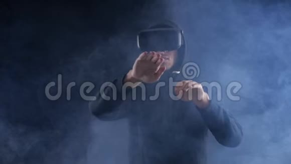 人获得使用VR头套在黑暗烟雾背景的经验增强现实设备创建虚拟空间视频的预览图