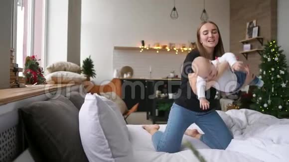 快乐欢笑的婴儿与快乐年轻微笑的母亲拥抱的肖像纯爱与幸福的场景家庭视频的预览图