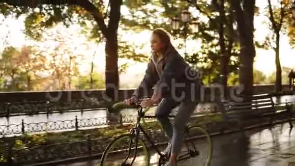 美丽的白种人女性骑自行车在早晨公园或大道一个年轻女子骑着徒步旅行的侧面景色视频的预览图