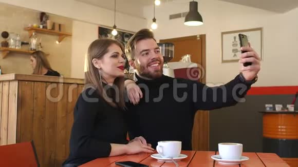 年轻夫妇在咖啡馆里拍照视频的预览图