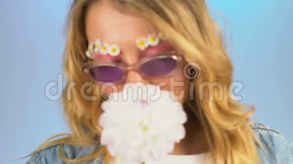 美丽的女孩有着雏菊而不是眉毛享受着甜美的达赫利亚斯香味视频的预览图