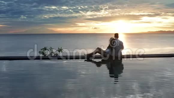 在豪华度假酒店的情侣浪漫的暑假人们一起在边缘游泳池放松享受视频的预览图