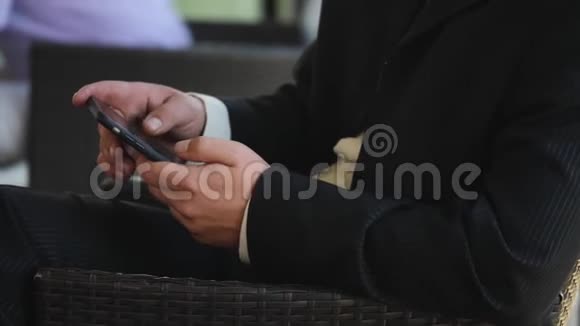 穿黑色西装的商人在智能手机上拨号码大手背景上的男子剪影这就是视频的预览图