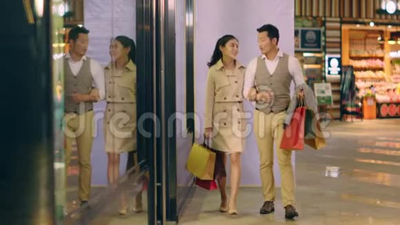 年轻的亚裔夫妇在购物中心散步视频的预览图