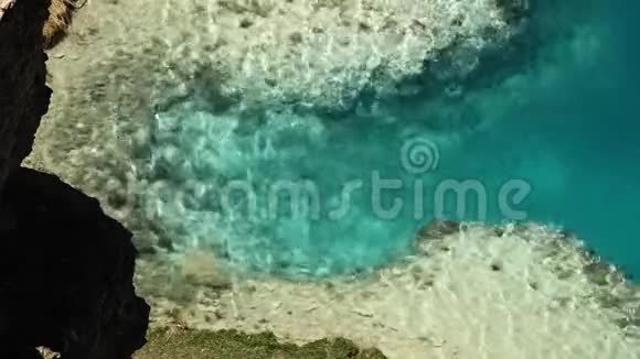 平静的绿松石色的水从浅湖床上倾泻而下视频的预览图