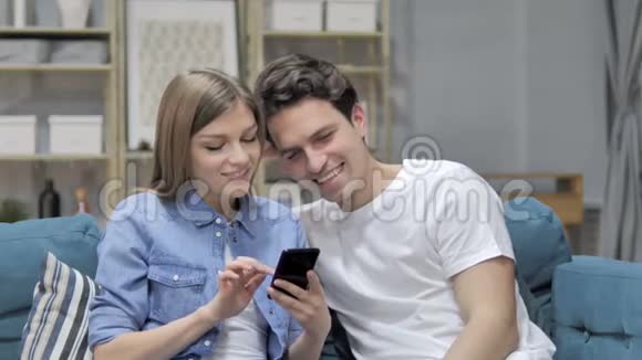 幸福小夫妻在家用智能手机上网视频的预览图