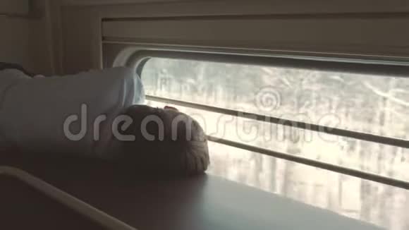 火车上的男孩躺在一辆二等车厢的顶层架子上看着窗户后景视频的预览图