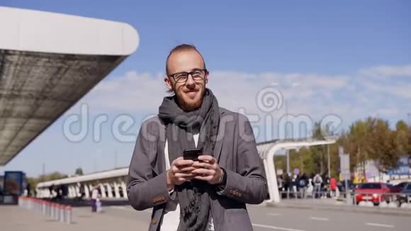 白人年轻人用智能手机发短信英俊的年轻商人使用智能手机户外活动视频的预览图