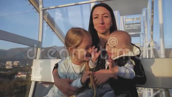 带着孩子坐摩天轮的年轻母亲度假旅游的概念视频的预览图