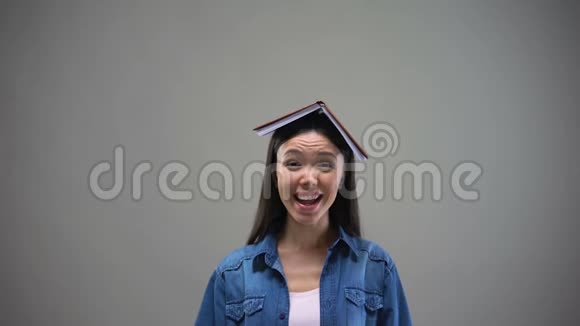 微笑的女人头上拿着书手指朝上大学广告视频的预览图