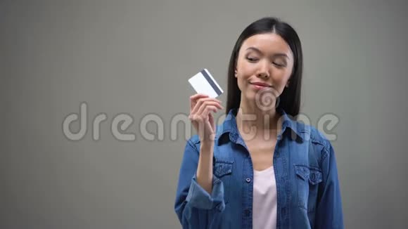 微笑的亚洲女人拿着信用卡想着购物没有限制视频的预览图