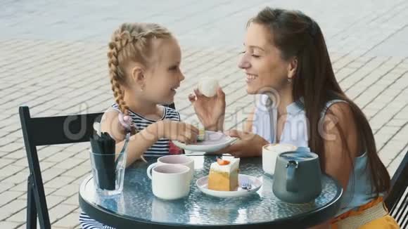 妈妈和她可爱的小女儿在户外咖啡馆视频的预览图