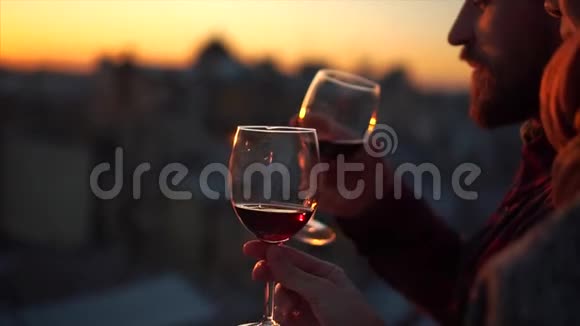 两只手和酒杯的轮廓在日落视频的预览图