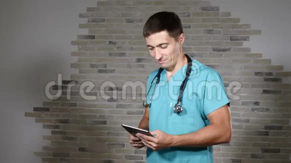 穿绿色军装的年轻男医生有趣的肖像年轻专家脖子上戴着听筒4k视频的预览图