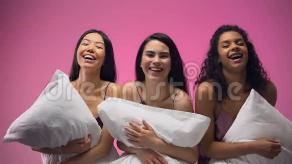 可爱的女人带着枕头开心地大笑穿着睡衣参加派对视频的预览图