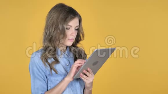 黄色背景下小女孩通过平板电脑进行视频聊天视频的预览图