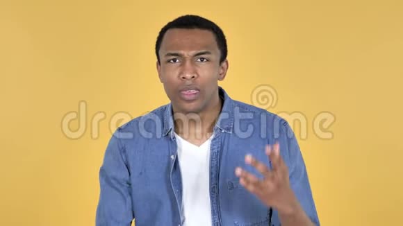 非洲青年男子战胜失败和问题黄色背景视频的预览图