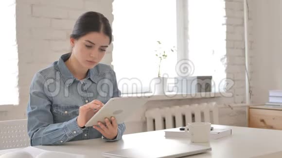 年轻女孩在平板电脑上浏览互联网视频的预览图