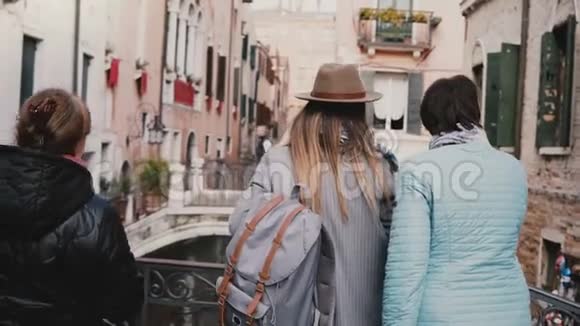 背景年幼的女儿和年迈的母亲一起站在运河桥上欣赏意大利威尼斯度假的风景视频的预览图