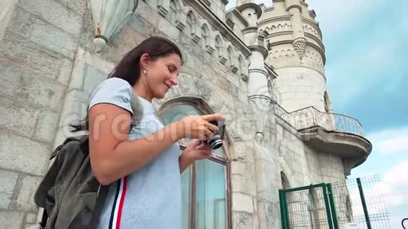 微笑背包女子欣赏古建筑拍摄中世纪城堡视频的预览图
