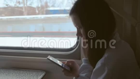 疲惫的年轻女子在火车上用手机看视频视频的预览图