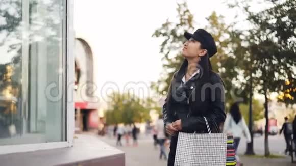 可爱的亚洲女孩看着商店橱窗里的东西然后遇见她的朋友年轻的女人拥抱着说话着展示着视频的预览图