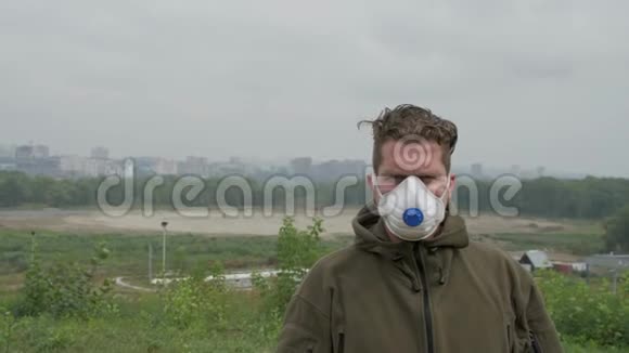年轻人站在城市的背景下戴着医用口罩在浓密的烟雾中视频的预览图