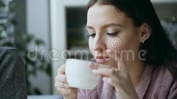 女孩在咖啡馆喝热茶视频的预览图