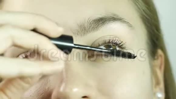 美女化妆女孩在睫毛上涂睫毛膏视频的预览图