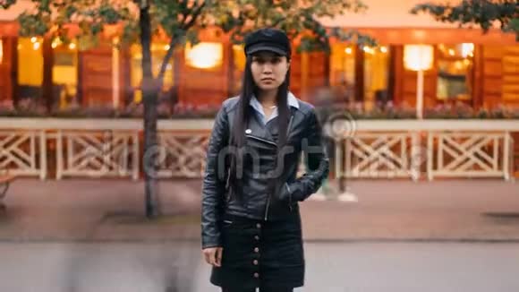 一位孤独的亚洲女士在傍晚时分看着站在街外的摄像机慢慢消失视频的预览图