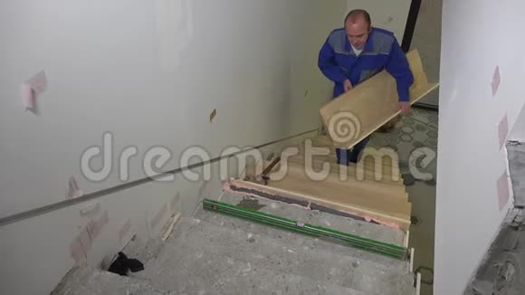 熟练工人在楼梯上安装木板检查楼梯水平视频的预览图